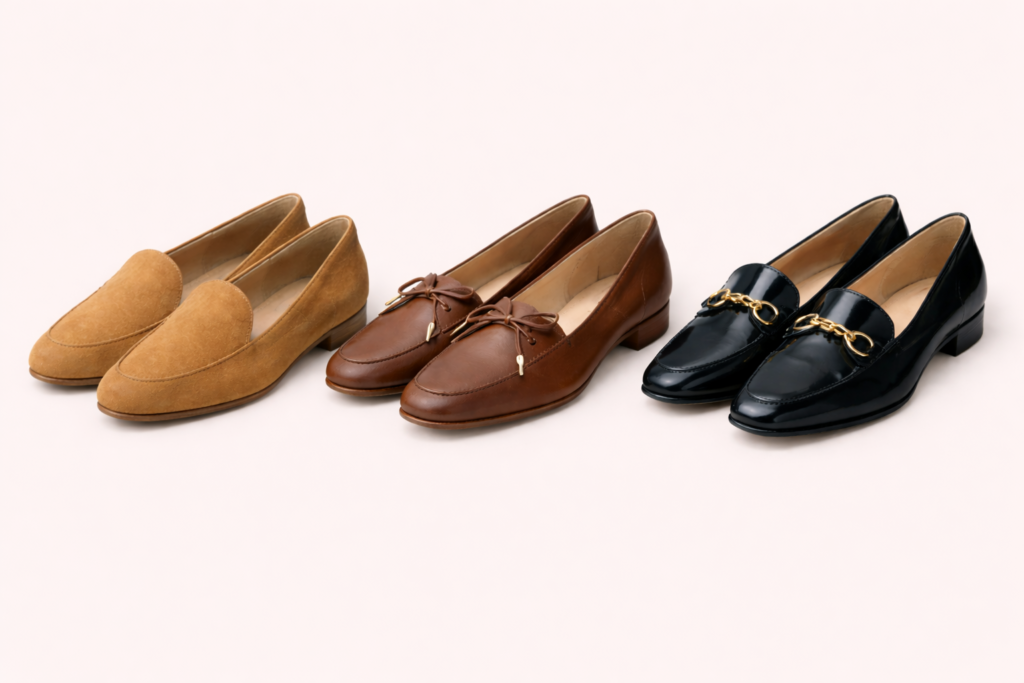 Trzy pary damskich loafersów obok siebie: jasno-rude zamszowe z zaokrąglonym noskiem, brązowe skórzane na niskim obcasie z kokardką i lekko kwadratowym noskiem oraz czarne eleganckie na połysk ze złotą ozdobną klamrą.
